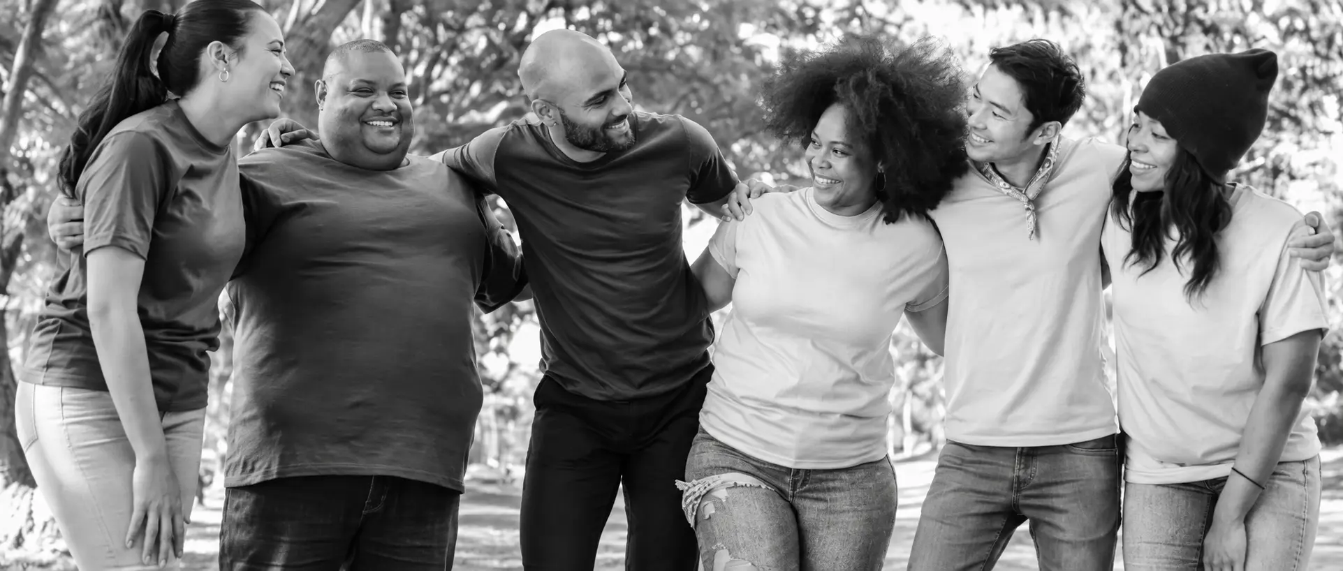 Six people standing together outdoors in black and white
